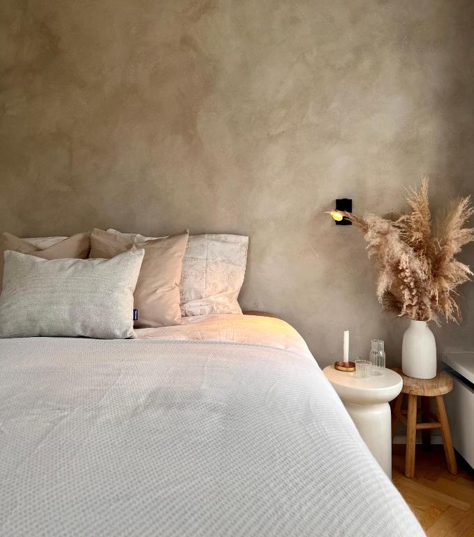 a bedroom with a bed and a table with a lamp at B&B De Rooman in Sint-Gillis-Waas