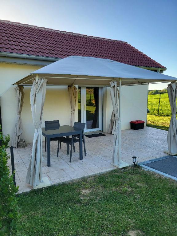 a gazebo with a table on a patio at L'Impasse du Jura in Ménétru-le-Vignoble