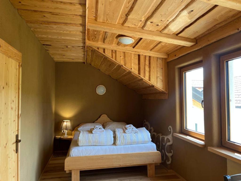 a bedroom with a bed in a room with wooden ceilings at Ethno holistic village Apače - Nature Retreat in Slovenia in Apače