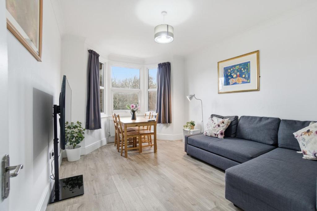 a living room with a couch and a table at Modern 2 bedroom flat, SE6 in Catford