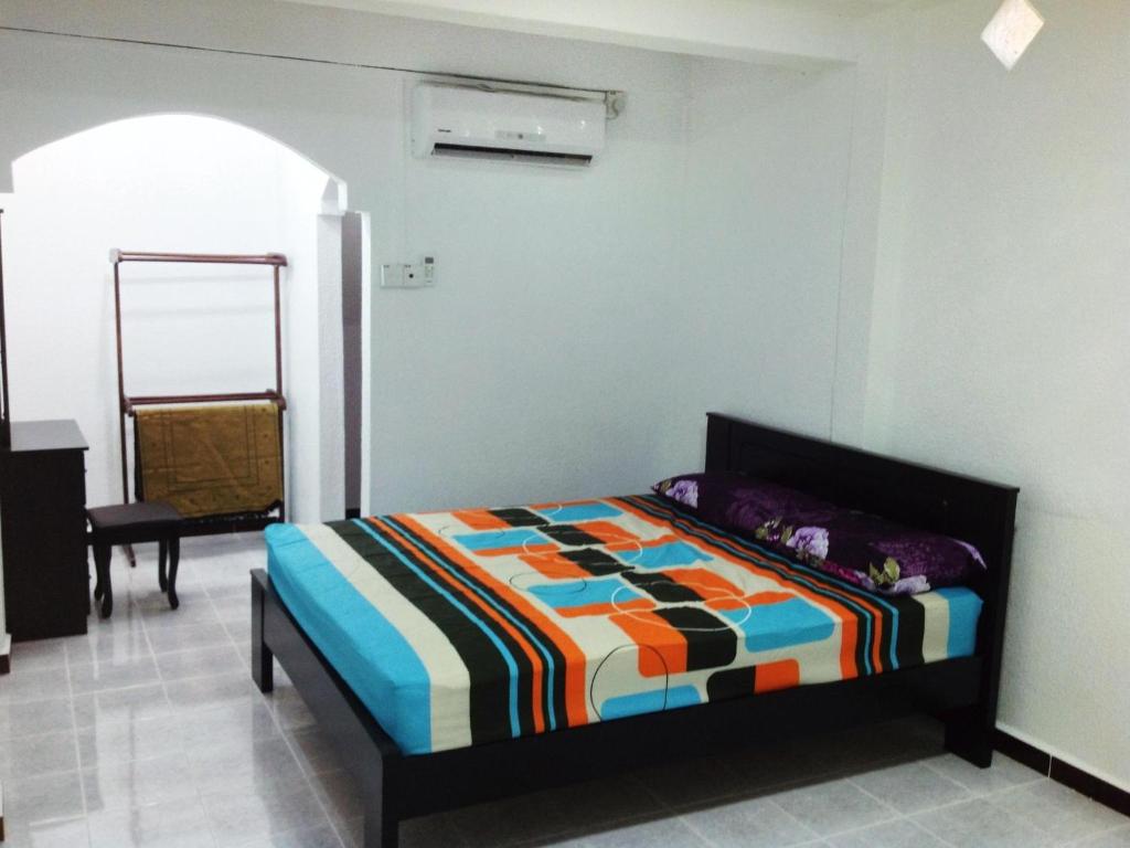 een slaapkamer met een bed in een kamer met een spiegel bij Nur Muslim 3 Homestay At Kota Bharu in Kota Bharu
