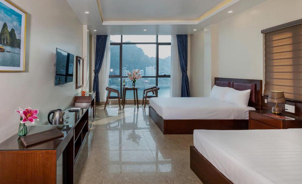 a hotel room with two beds and a table at Song Nga Boutique Hotel Cat Ba in Cat Ba