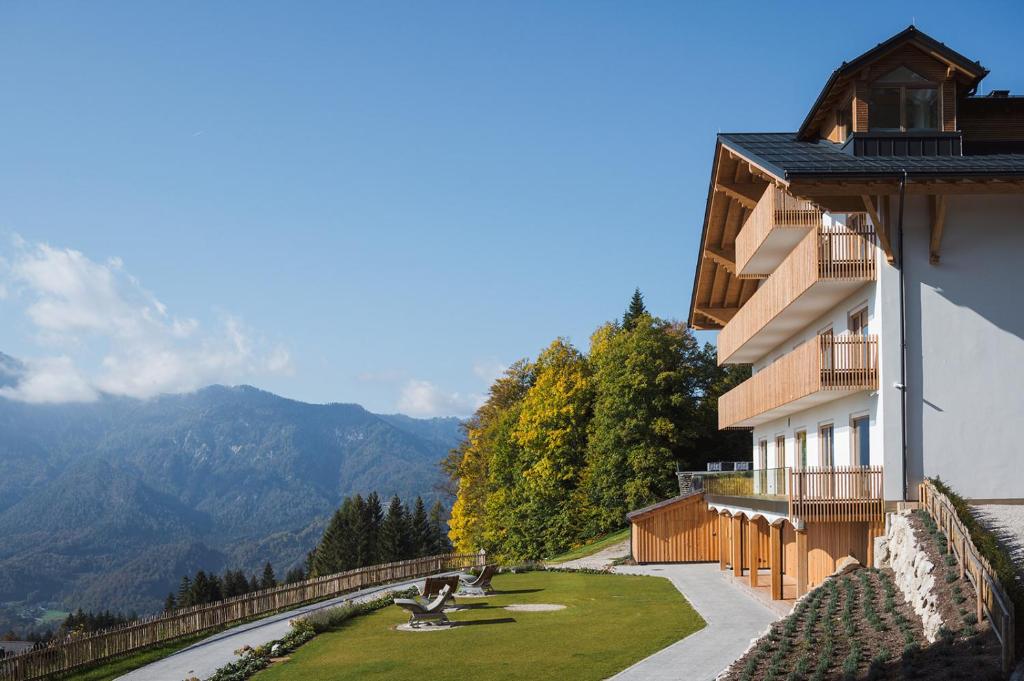 a building with a lawn next to a mountain at Berghotel Predigstuhl in Bad Goisern