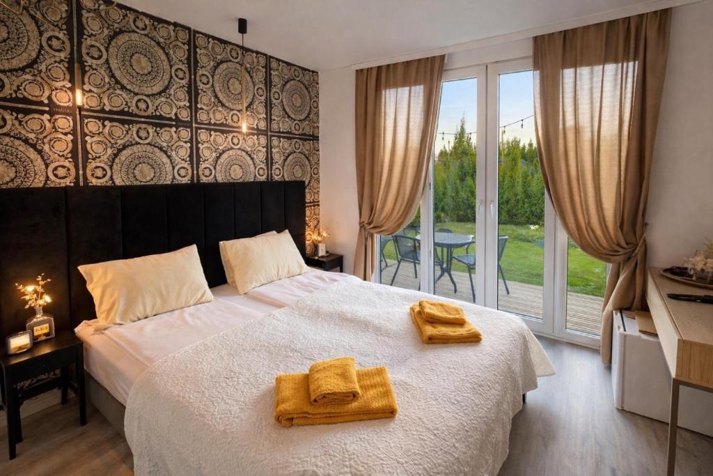 a bedroom with a bed with two towels on it at MMA Apartament with Private Garden & Terrace in Klaipėda