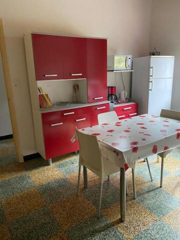 a kitchen with red cabinets and a table and chairs at Paul in Serra-di-Ferro