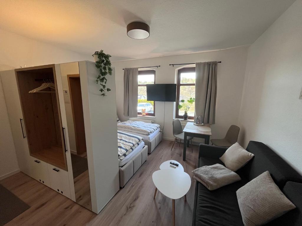 a bedroom with a bed and a living room at Gästewohnung Mable in Greiz