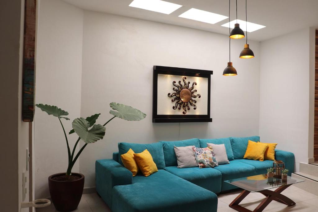 a living room with a blue couch with yellow pillows at Casa La Vikina in Guanajuato