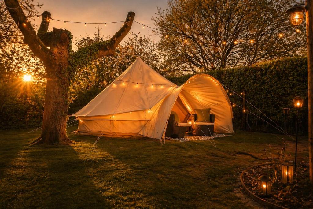 a tent sitting in the grass next to a tree at Glamping auf dem Weberhof in Münster