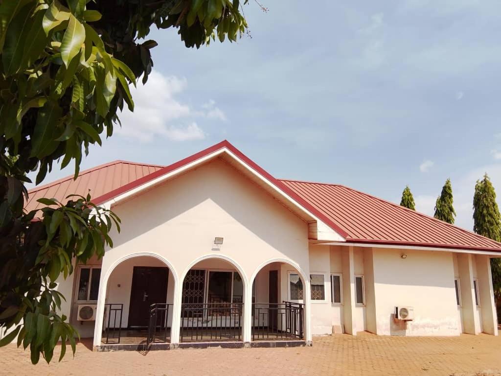 a large white building with a red roof at S & J Lodge with high speed Starlink WiFi in Tamale