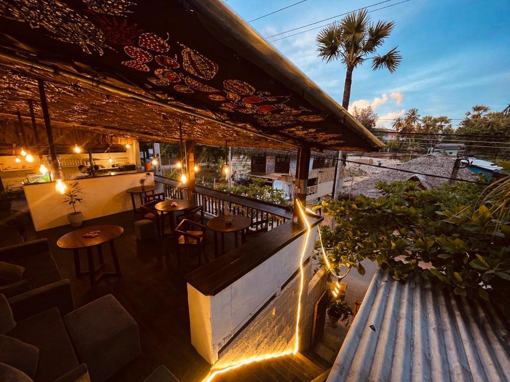 a restaurant with tables and chairs on a balcony at Casa Moon Trincomalee Beach House in Trincomalee