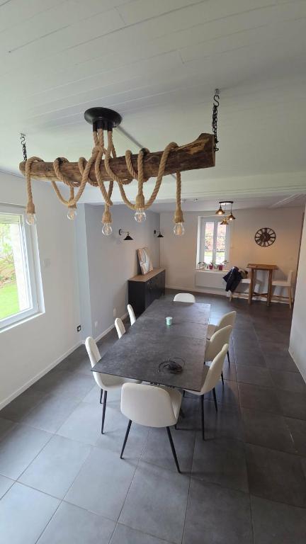 a dining room with a table and chairs at La liberté des trois petits cochons avec spa in Lalizolle