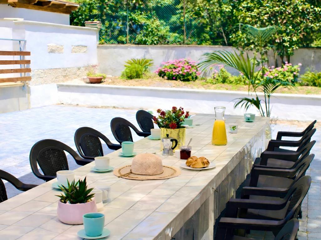 a long table with chairs and food on it at Thalassa Holiday Home with Terrace near the Sea - Anzio in Anzio