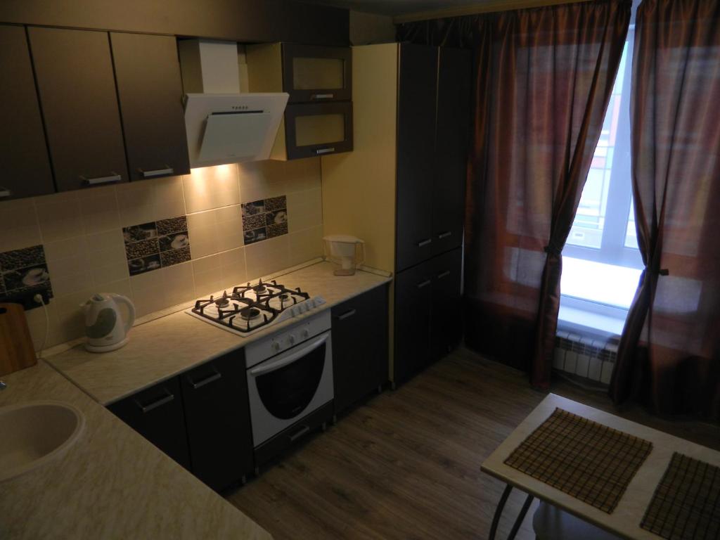 a small kitchen with a stove and a sink at Apartment on Marshala Ustinova 10 in Samara