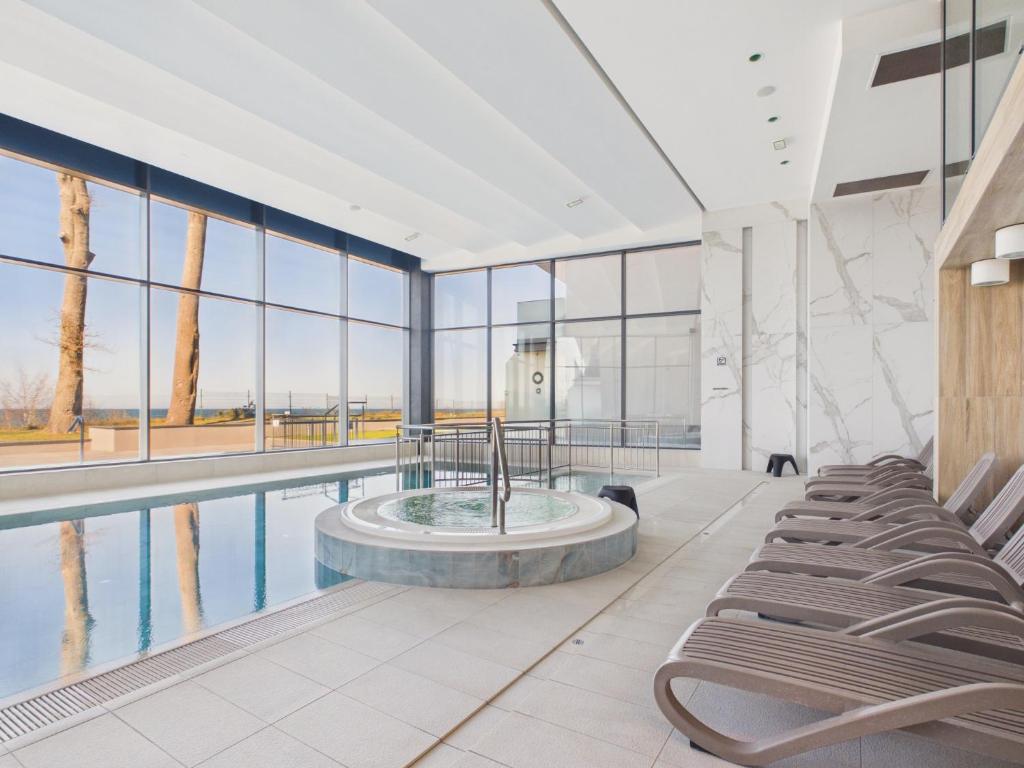 a lobby with a pool with chairs and a fountain at Baltic Horizon Klifowa by Solarento in Rewal