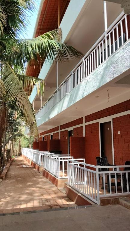 a building with a white railing and a balcony at Lotus Leaf Resort, Murud in Murūd