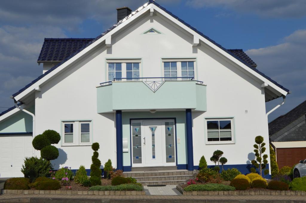 een wit huis met blauwe rand bij Ferienwohnung am Park - Vulkanferien in Plaidt