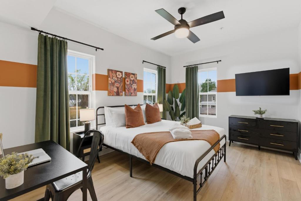 a bedroom with a bed with a ceiling fan and a desk at The Lofts On Maney – Boutique Loft in Downtown Murfreesboro in Murfreesboro