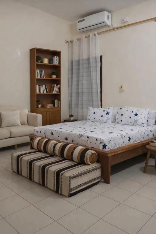 a large bed in a room with a couch at RÉSIDENCE KFS bTp in Tambacounda