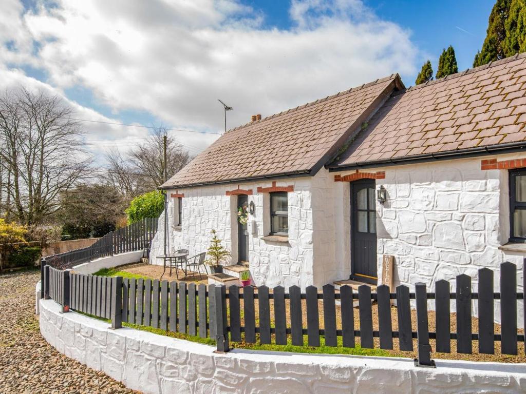 a small white cottage with a wooden fence at 1 Bed in New Moat oc-77692 in New Moat
