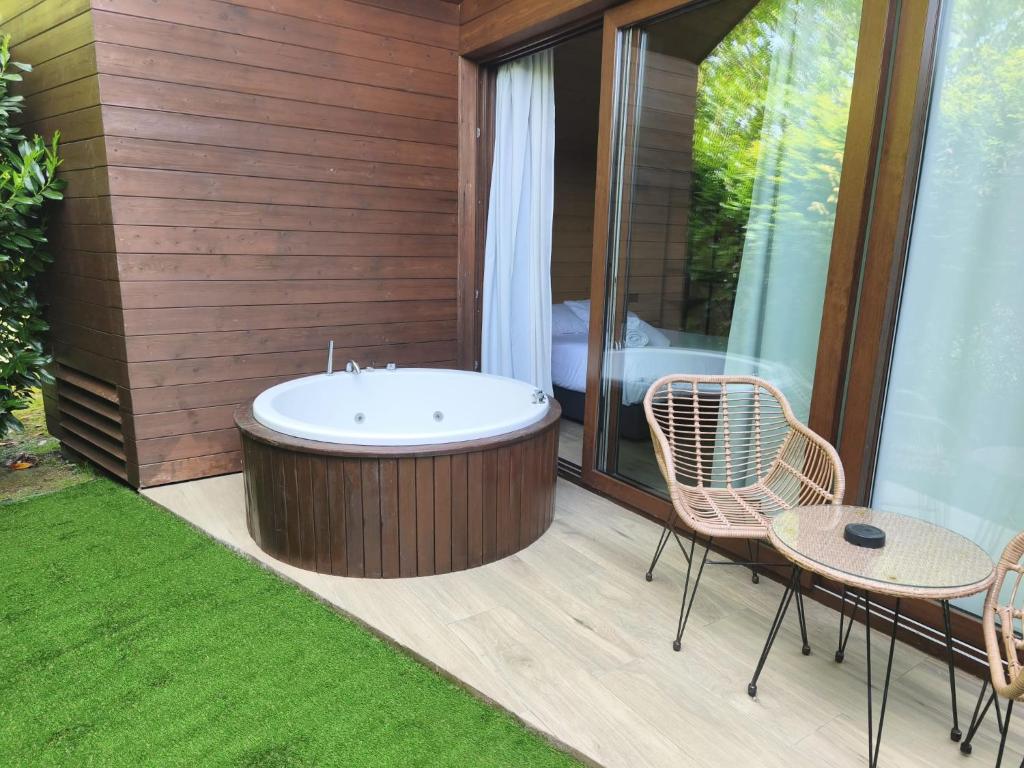 a bath tub on a deck with a table and chairs at Algar Carnota in Carnota