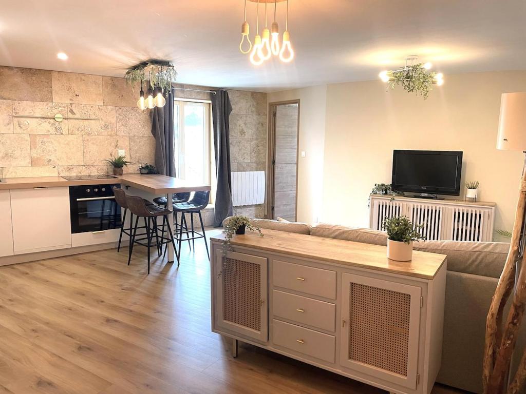 a living room and kitchen with a couch and a table at Le Barral in Voiron