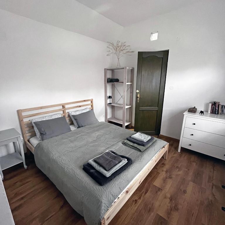 a bedroom with a large bed and a wooden floor at Kisház in Kisoroszi
