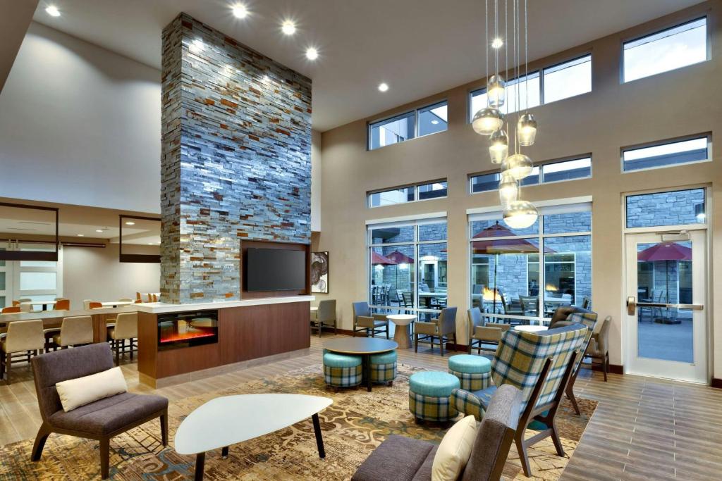 a lobby with chairs and tables and a fireplace at Residence Inn by Marriott Claremont in Claremont