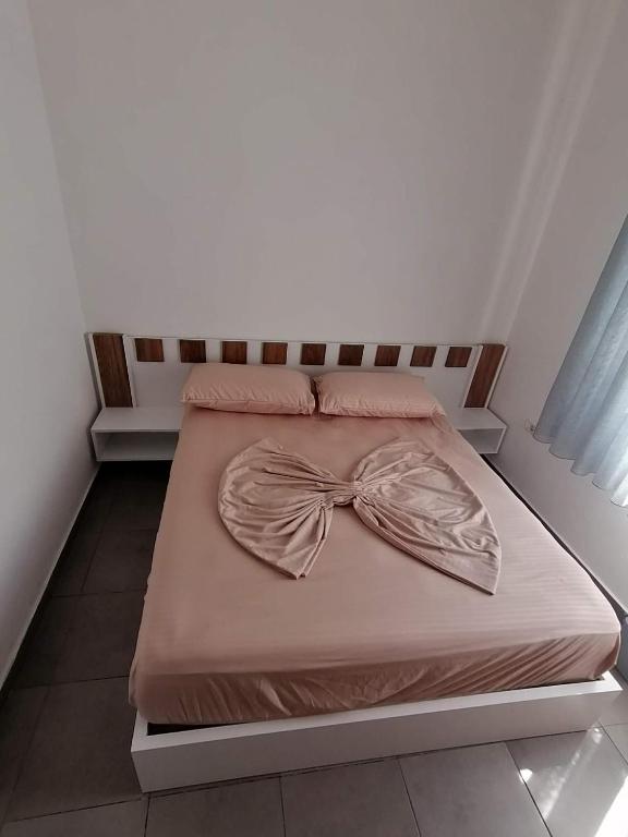 a bed with a bow tie on top of it at Holiday house in Laknas