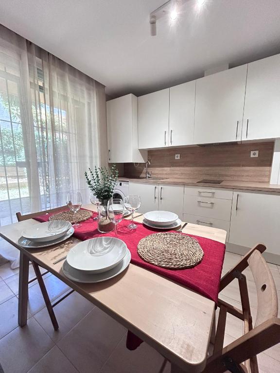 a kitchen with a wooden table with plates and wine glasses at Ocean Corner Dúplex Empul in Los Caños de Meca