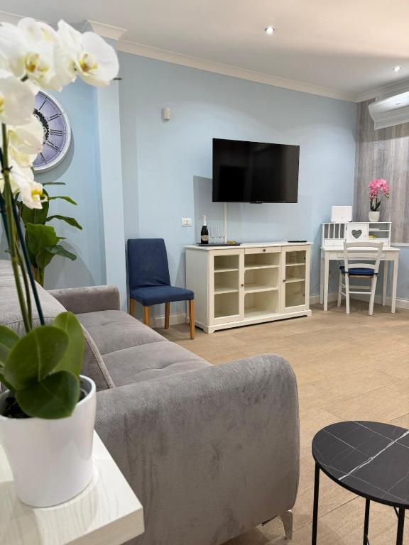 a living room with a couch and a flat screen tv at Beach house airport in Fiumicino