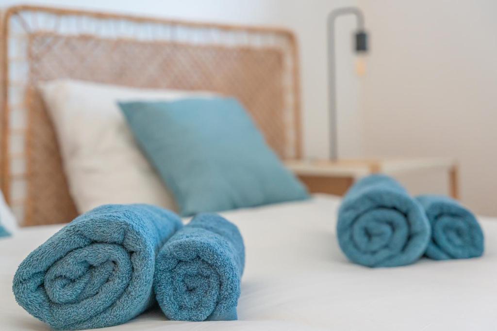 a pile of blue towels on a bed at Baleal Bay Guesthouse in Baleal