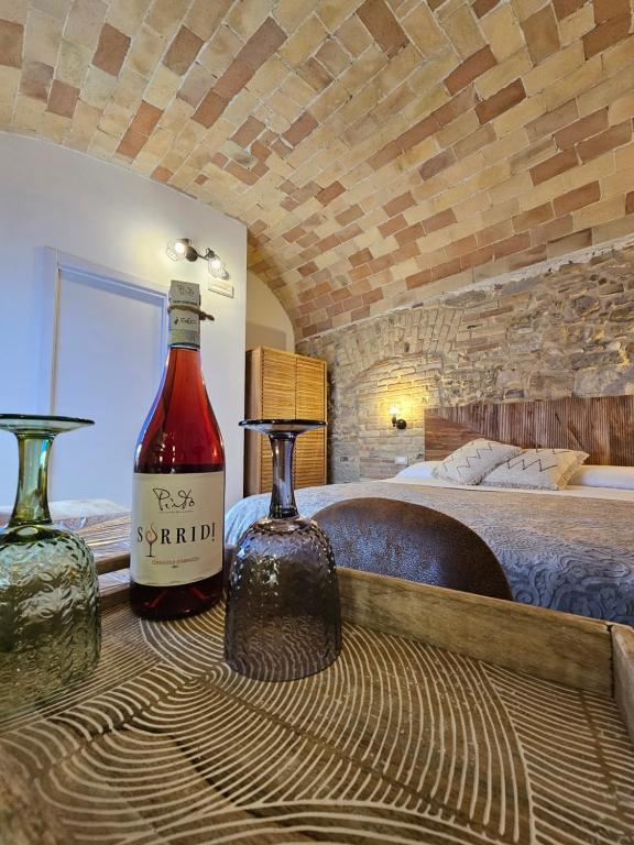 two bottles of wine sitting on a table in a bedroom at Borgo del Marchese in Ortona