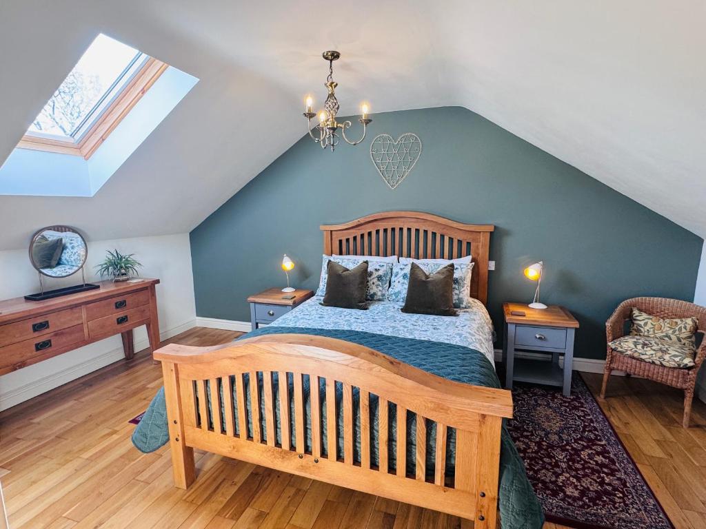 a bedroom with a wooden bed and a blue wall at Vale View Cottages - The Stables in Prestatyn