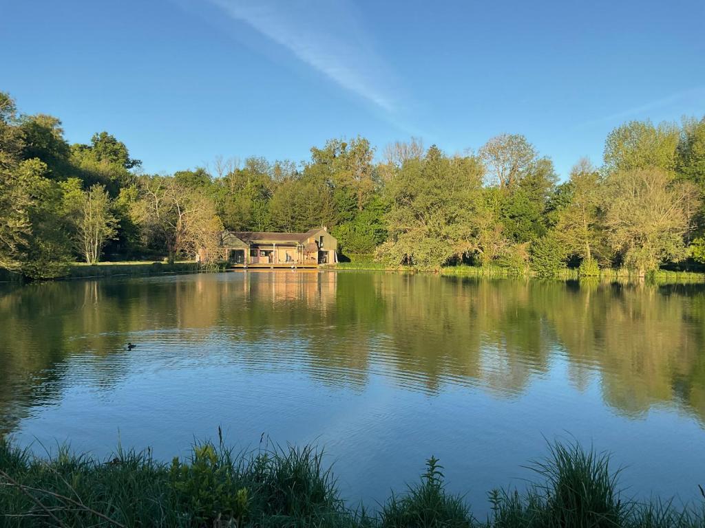 a house sitting on top of a large lake at Logement au bord de l eau in Dordives