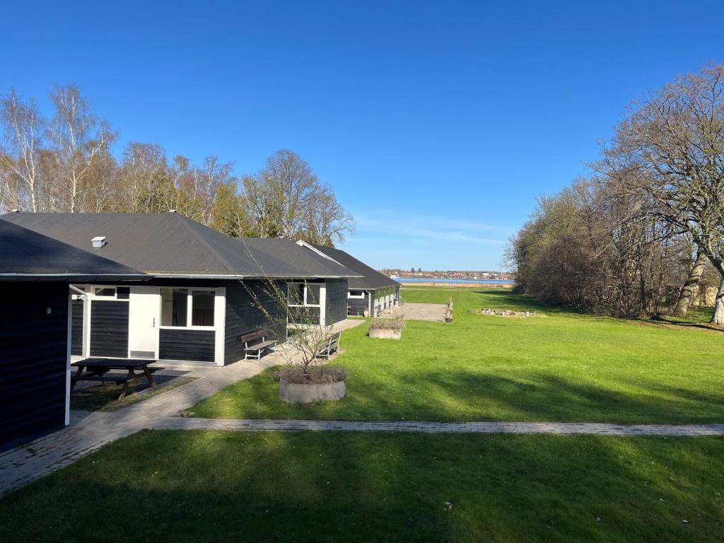a house with a large yard with a grass field at Hotel Færgelunden in Jægerspris