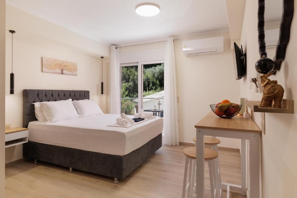 ein Schlafzimmer mit einem Bett, einem Tisch und einem Fenster in der Unterkunft Plaka Studios 3 in Benitses