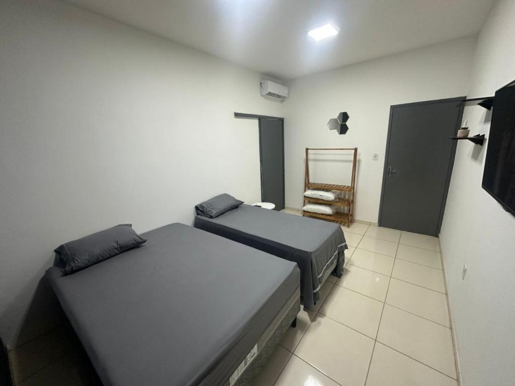 a room with two beds and a chair in it at Apto Centro Arapiraca in Arapiraca