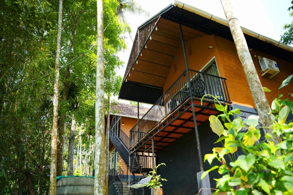 an orange building with stairs leading up to it at Wanderlust Villas in Pinangode