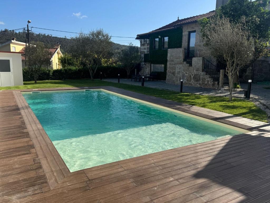 a swimming pool with blue water in a yard at Santa Baia in Veiga