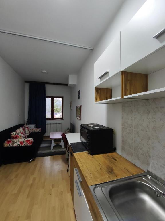 a kitchen and living room with a sink and a couch at Hideout apartments Travnik in Travnik