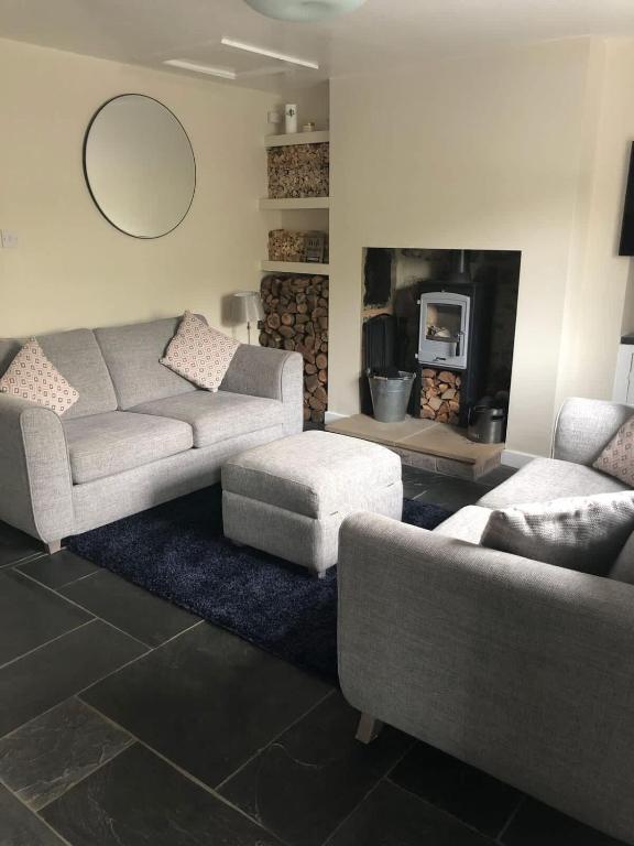 a living room with a couch and a fireplace at 2, The Lodge, Tideswell in Tideswell