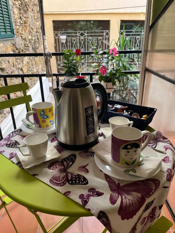 a table with a tea kettle and cups on it at Magia e Luce in Sanremo
