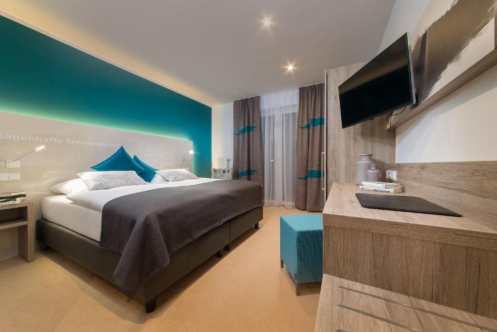 ein Hotelzimmer mit einem Bett und einem Flachbild-TV in der Unterkunft Allgäu Art Hotel in Kempten