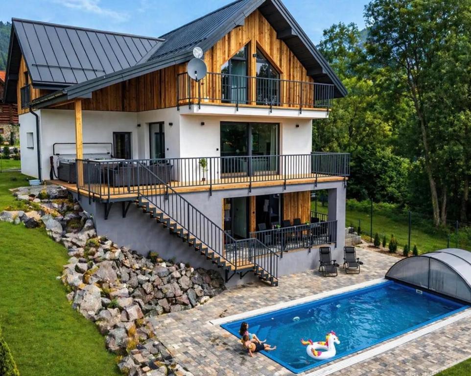 a house with a swimming pool in front of it at Chata Wellness Liptov in Ižipovce