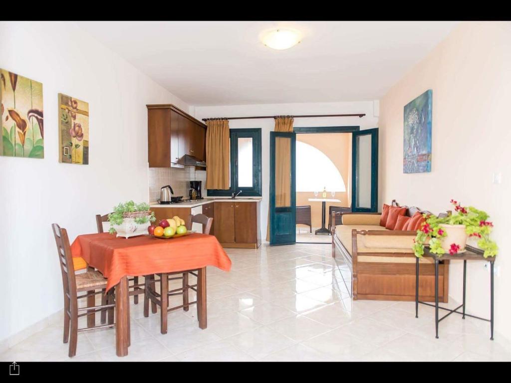 a kitchen and living room with a table and a couch at Archipelagos Apartments in Arkasa