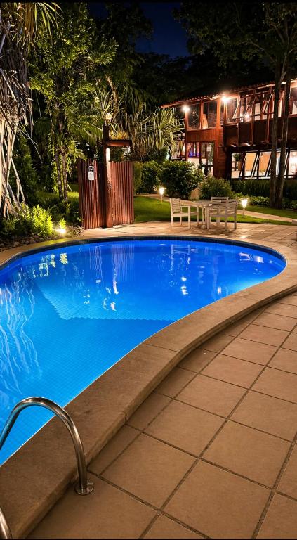 a large blue swimming pool at night at Pousada Coisa e Tao in Arraial d'Ajuda