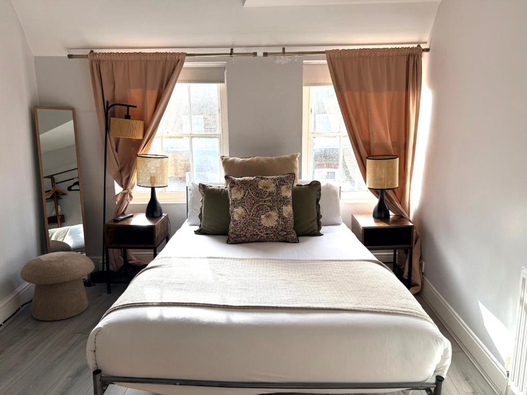 a bedroom with a bed with two lamps and a mirror at Soho Room n4 in London