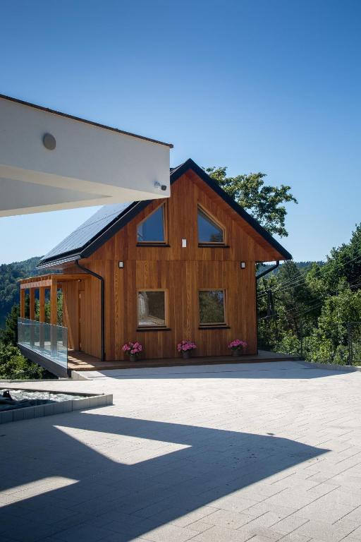 a large wooden house with a lot of windows at Domek Nad Jeziorem 6 osobowy in Rożnów