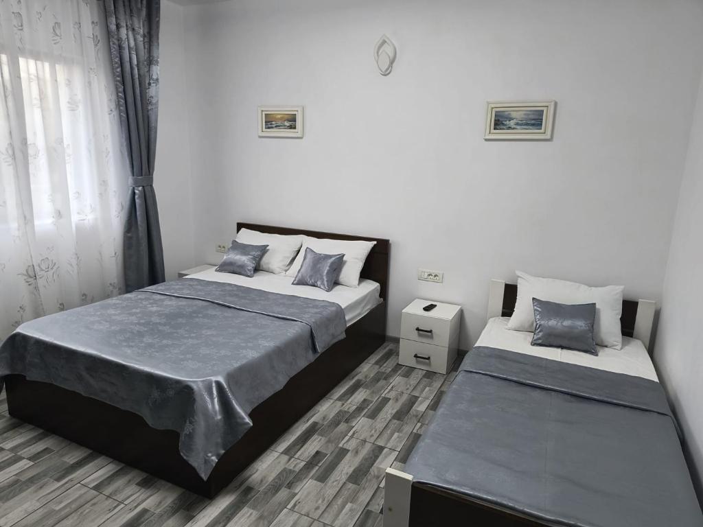 two beds in a room with white walls at Casa Dorului in Mangalia