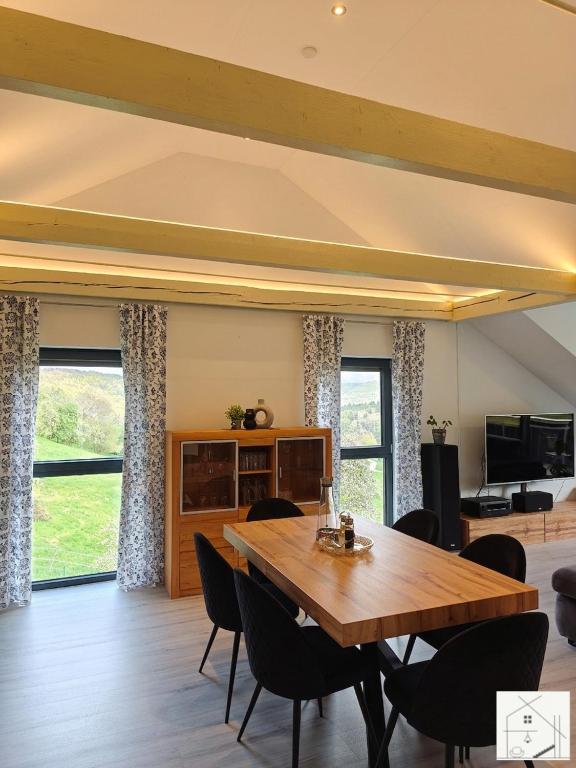 ein Esszimmer mit einem Holztisch und Stühlen in der Unterkunft Lichtloft Fränkische Schweiz in Ebermannstadt